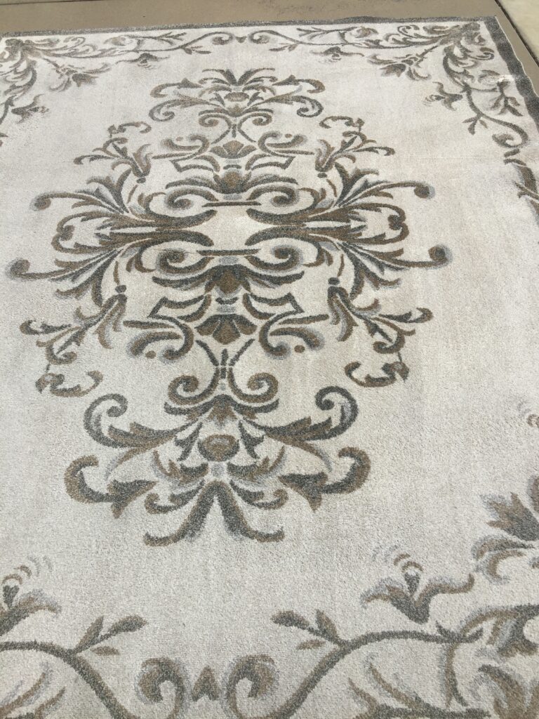 Elegant beige carpet with intricate brown floral patterns.